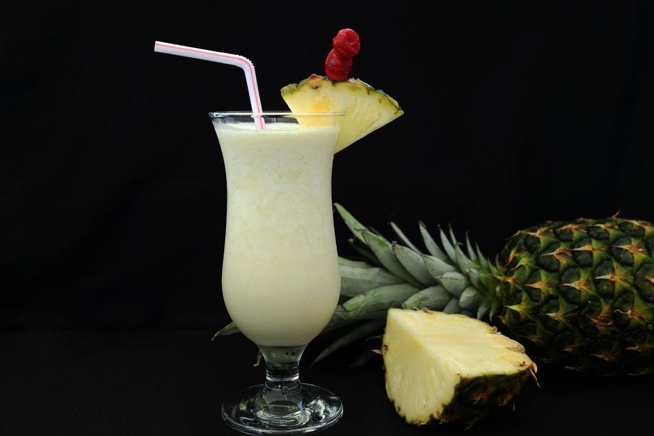 Close-up of a pina colada with pineapple garnish and straw, perfect for a tropical vibe.